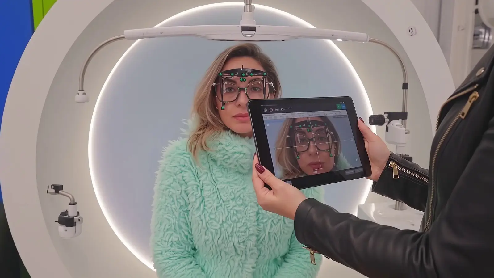 Cliente com a armação de prova durante a medição digital, com a leitura aparecendo no tablet ao lado